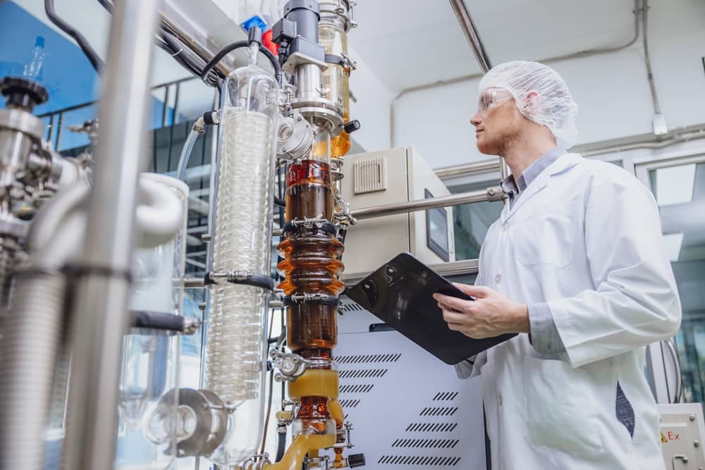 scientist in front of equipment extracting oil from cannabis